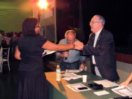 A funcionária Valéria Regina Pessanha Fonseca (COM) recebe os cumprimentos do Vice-Reitor Comunitário prof. Augusto Sampaio e do Reitor Prof. Pe. Josafá Carlos de Siqueira S.J. Fotógrafo Antônio Albuquerque. Acervo do Núcleo de Memória.