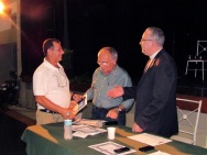 O funcionário Wellington Figueiredo (LET) recebe os cumprimentos do Vice-Reitor Comunitário prof. Augusto Sampaio e do Reitor Prof. Pe. Josafá Carlos de Siqueira S.J. Fotógrafo Antônio Albuquerque. Acervo do Núcleo de Memória.