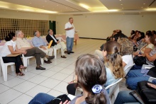 No Salão da Pastoral, sentados, Rita Luquini, Prof. Fernando Ferreira, Prof. Augusto Sampaio e o Reitor Prof. Pe. Josafá S.J., e, de pé, o Prof. Miguel Pereira. Fotógrafa Camille Valbusa. Acervo do Projeto Comunicar.