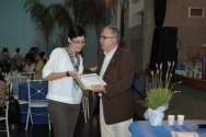 O Reitor Prof. Pe. Josafá faz a entrega do diploma de Honra ao Mérito à professora Erica dos Santos Rodrigues, do Departamento de Letras. Fotógrafo Antônio Albuquerque. Acervo do Núcleo de Memória.