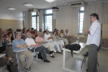 O Prof. Eduardo Jardim apresenta o palestrante na sala F502. Sentados na primeira fila à esquerda o Prof. Ricardo Benzaquen e o palestrante Prof. Eduardo Jardim. Fotógrafo Antônio Albuquerque. Acervo do Núcleo de Memória.