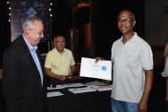 O Reitor Prof. Pe. Josafá S.J. faz a entrega do diploma de Honra ao Mérito ao funcionário Carlos Augusto de Oliveira (FIS), por seus 45 anos de dedicação à PUC-Rio. Ao fundo, o Prof. Augusto Sampaio. Fotógrafo Antônio Albuquerque. Acervo Núcleo de Memória.