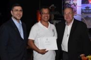 O Reitor Prof. Pe. Josafá S.J. faz a entrega do diploma de Honra ao Mérito ao funcionário Nilton Cesar Ferreira Gomes, do Departamento de Física, por seus 30 anos de dedicação à PUC-Rio. Ao lado, o Vice-Reitor Pe. Álvaro Pimentel S.J..